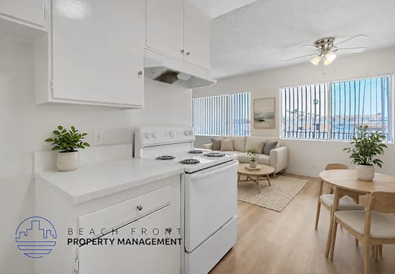 A kitchen with white appliances and a dining table with chairs.