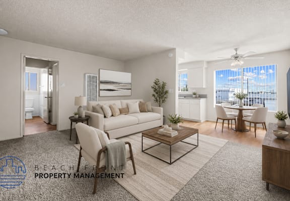 A living room with a white couch, a coffee table, and a dining table with chairs.