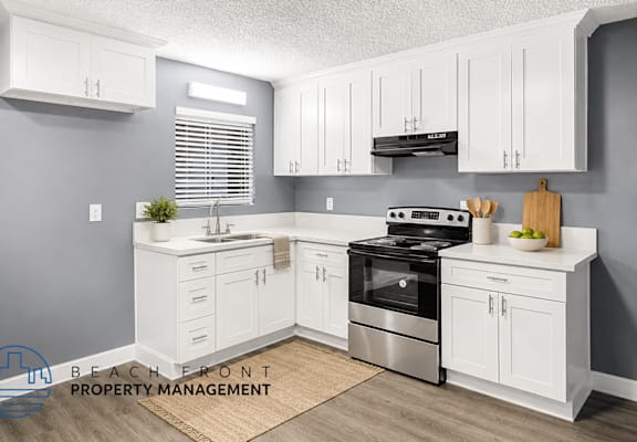 A kitchen with white cabinets and a stainless steel stove.