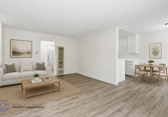 A living room with a white couch, a coffee table, and a dining table with chairs.