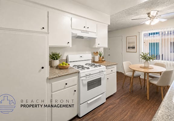 A kitchen with white appliances and wooden floors.