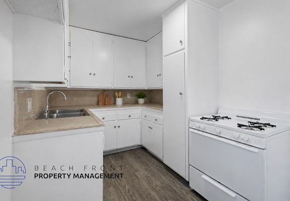 A kitchen with white cabinets and a stove top oven.
