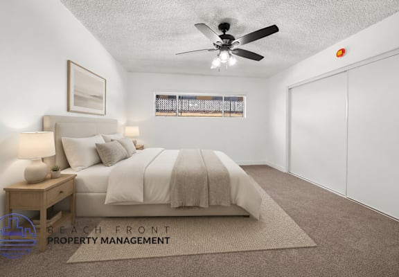A bedroom with a bed, nightstand, and window.