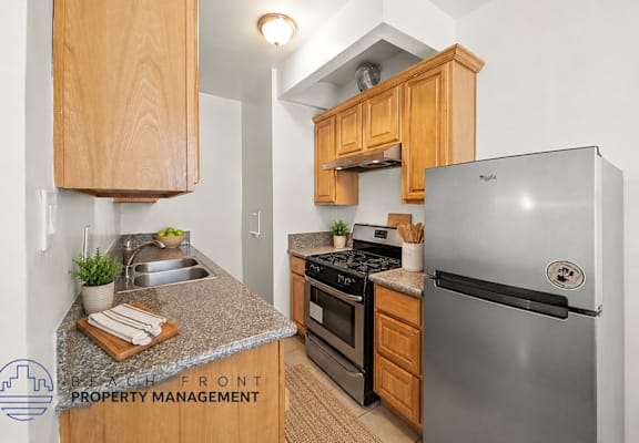 A kitchen with a refrigerator, stove, and oven.