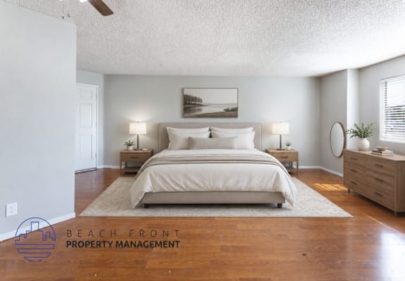 A bedroom with a large bed, two nightstands, and a ceiling fan.