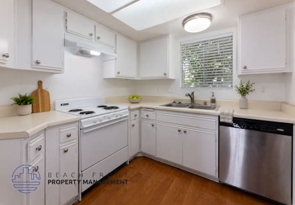 A kitchen with white cabinets and a stainless steel dishwasher.