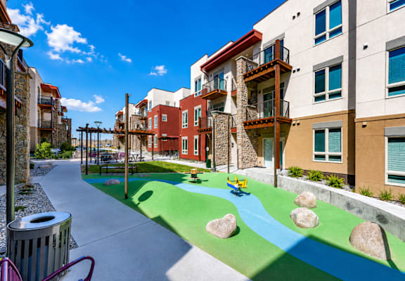 A playground with a blue and green surface and rocks.