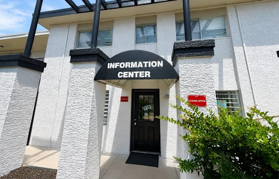 The front of a building with a black door and a sign that says Information Center.