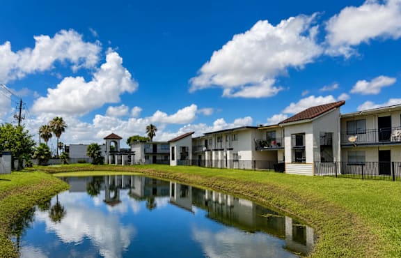 A pond in front of a row of houses.