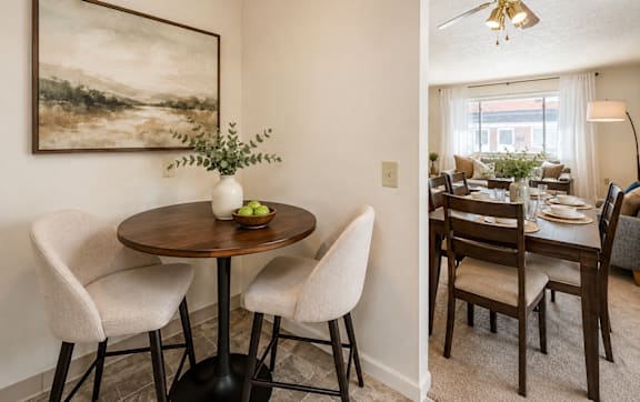 A dining room with a table and chairs.