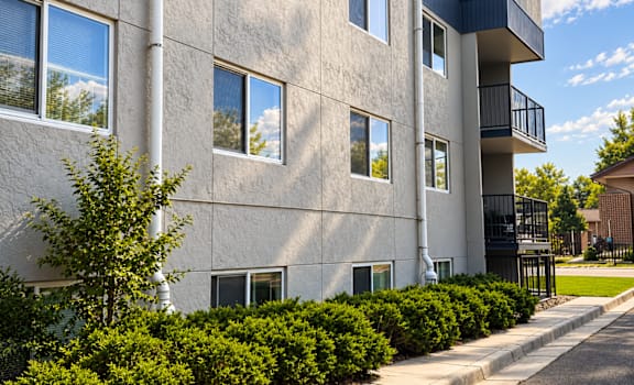 A grey building with a balcony on the second floor.