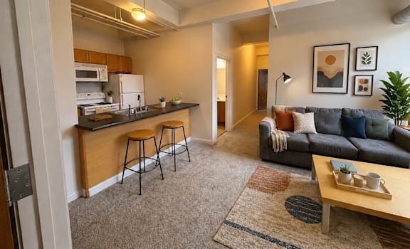 A living room with a grey couch and a wooden coffee table.