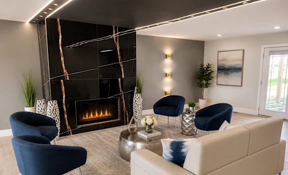 A living room with a fireplace and blue chairs.