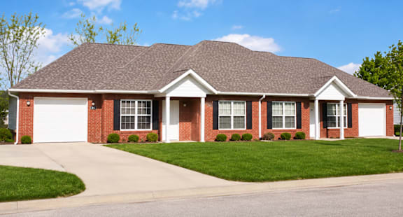 A red brick house with a white garage door.