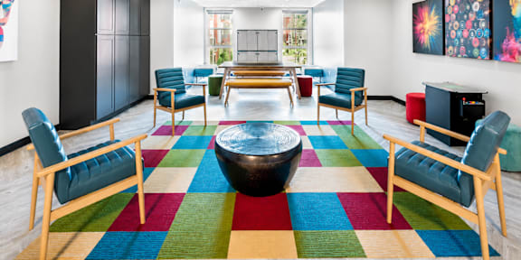 A room with a colorful rug and wooden furniture.