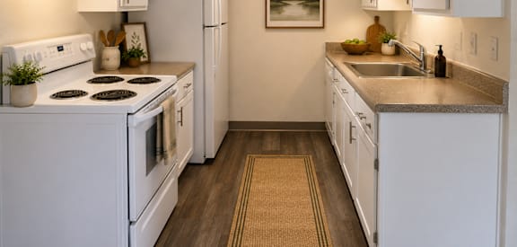A kitchen with white appliances and cabinets.