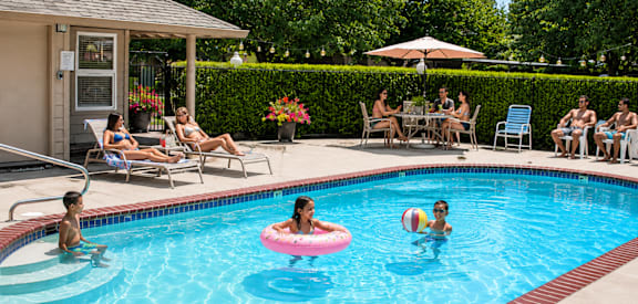 People are enjoying their time in the pool with inflatable rings.
