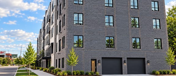 A modern grey building with black garage doors and windows.