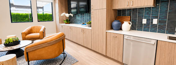 A modern kitchen with wooden cabinets and a dining table.