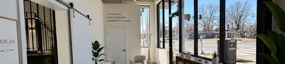 A modern office space with a desk, chair, and large windows.