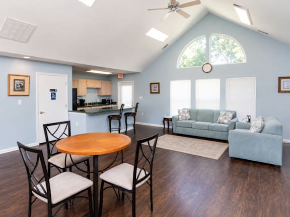 A dining table with four chairs around it in a room with blue walls.