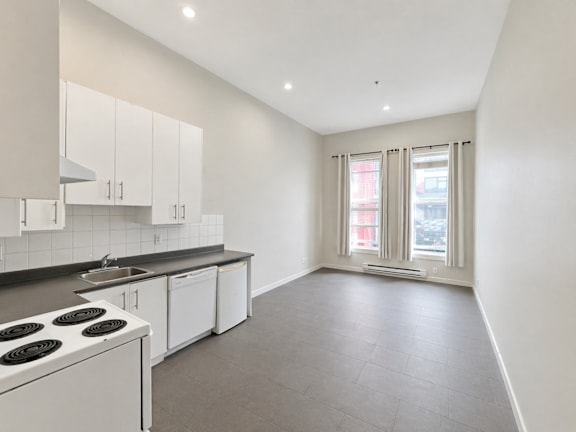 A kitchen with white cabinets and a stove top oven.