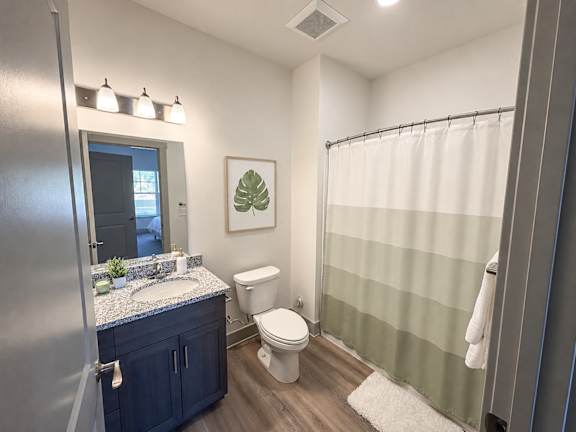 A bathroom with a toilet, sink, and shower.