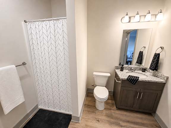 A bathroom with a toilet, sink, and shower.