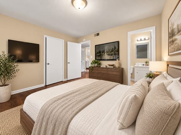 A bedroom with a large bed and a painting on the wall at Signature Collection in Tuscaloosa, AL, 35405.