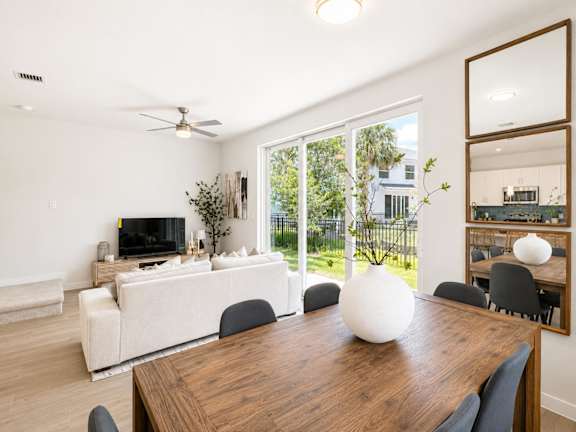 A modern dining room with a wooden table and chairs.