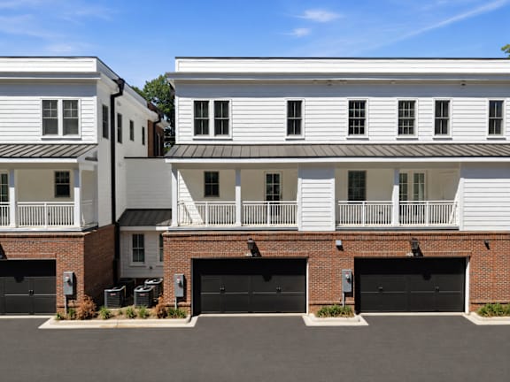 A white building with black garage doors in front.