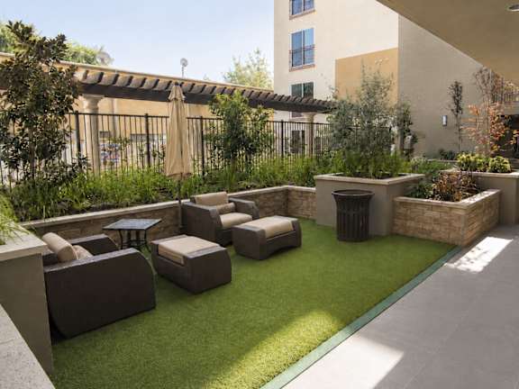 A patio with a lawn and furniture.