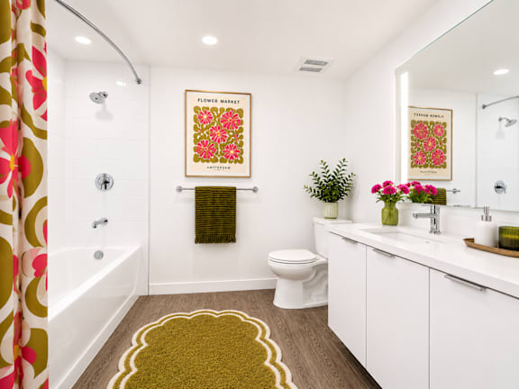 A bathroom with a toilet, sink, and a poster on the wall at Fusion Hollywood.