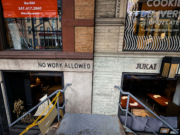 A sign on a building reads "NO WORK ALLOWED".