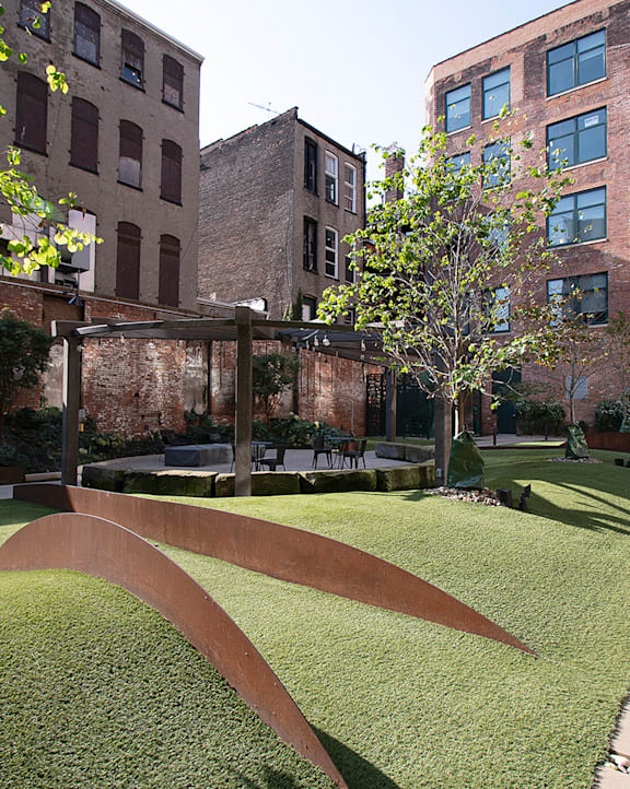 A park with a grassy area and a metal structure.