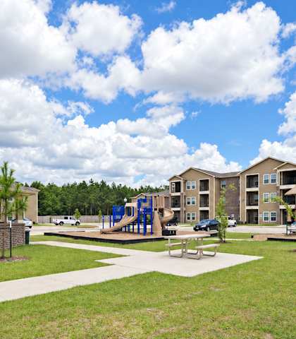 A playground area in front of apartment buildings.