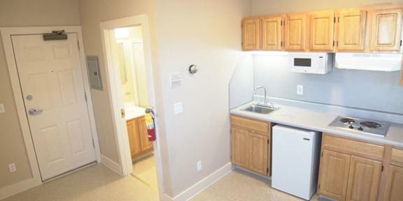 A kitchen with a black counter top and a white fridge.