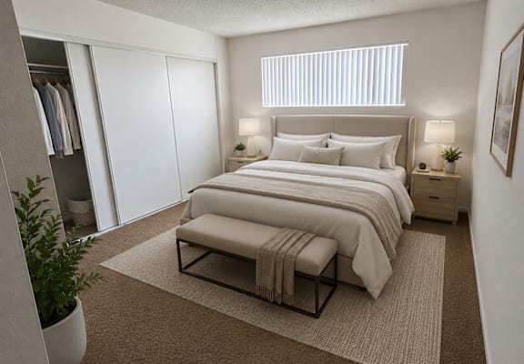 A bedroom with a large bed, a bench, and a plant.
