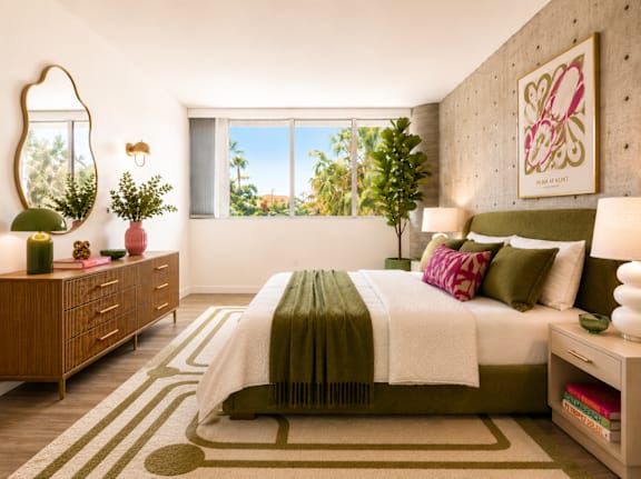 A bedroom with a large bed and a mirror on the wall at Fusion Hollywood.