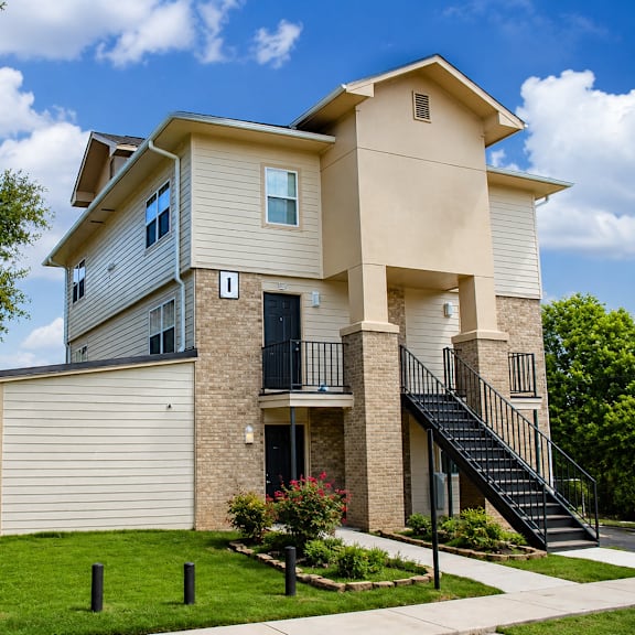 A two-story house with a balcony and a staircase leading to the second floor.
