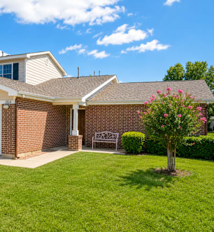 A house with a white garage door and a brick wall.