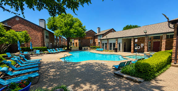 A pool surrounded by palm trees and a building.