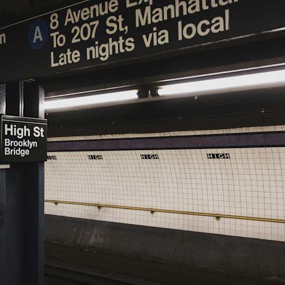 Sign at a subway station reading High Street Brooklyn Bridge.