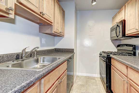 the kitchen has granite counter tops and wood cabinets