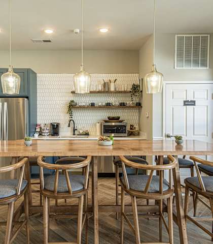 a kitchen with a large wooden table and chairs