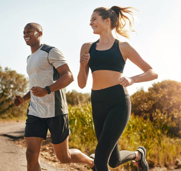 a man and a woman running down a road at Avellan Springs Apartments in Morrisville, NC 27560
