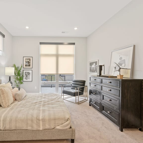 A bedroom with a large bed, a chair, and a dresser. at Four23/Hoge, Cincinnati, OH, 45226