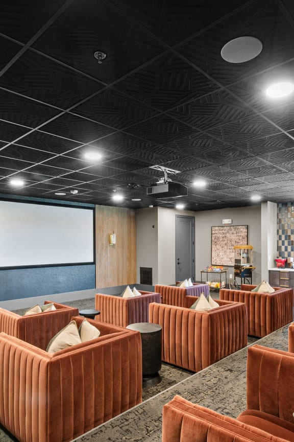 a large conference room with couches and a projection screen