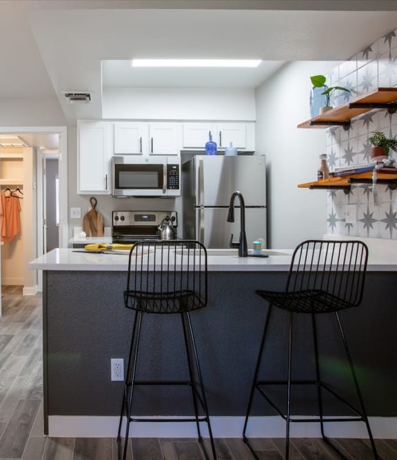 a kitchen with a breakfast bar and stools at Ascent 1829, Phoenix