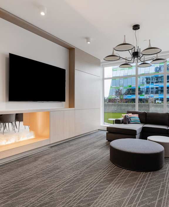 A modern living room with a large flat screen TV mounted on the wall.